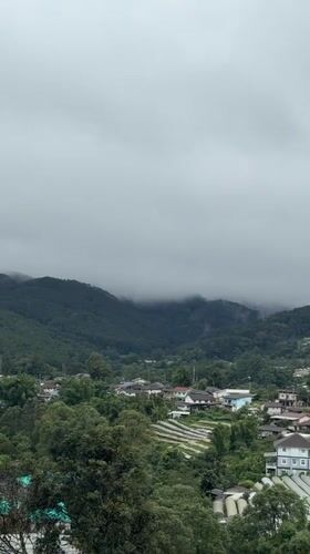 Waterfall and greenhouse farming on a misty Thai hillside