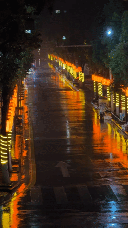 Rainy night creates reflective street scene in Wulingyuan