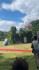 Woman takes coffee selfies at formal outdoor event