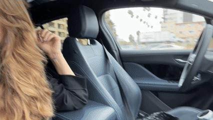 Woman drives through Los Angeles street under overcast skies