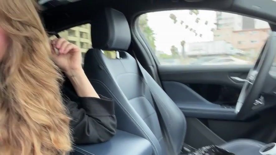 Woman drives through Los Angeles street under overcast skies
