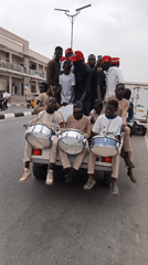 Street celebration with drums and vehicles in Tudun Wada