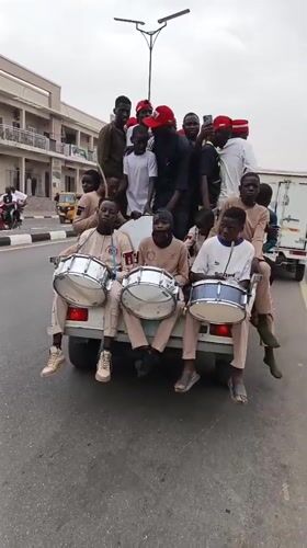 Street celebration with drums and vehicles in Tudun Wada