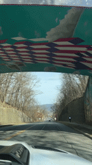 Vehicle travels road beneath mural-decorated pedestrian bridge in Newburgh
