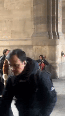 Street musicians perform violin and cello in Paris archway
