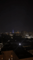 City towers illuminate nighttime skyline in colorful display