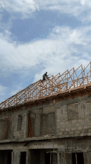 Construction workers frame roof on building project