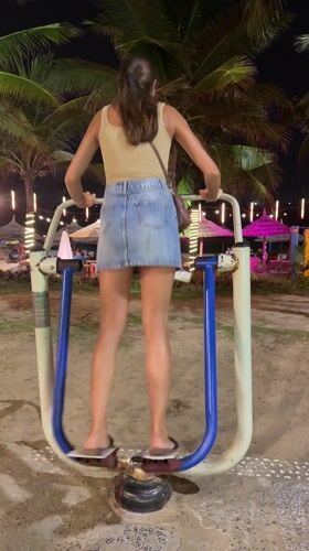 Woman exercises at beachfront outdoor gym in Da Nang