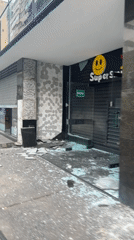 Vandalized storefront with shattered glass in Caracas