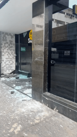 Vandalized storefront with shattered glass in Caracas