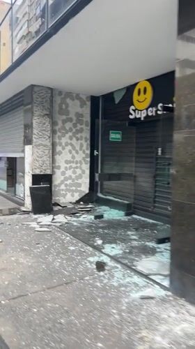 Vandalized storefront with shattered glass in Caracas