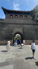 Tourists pass through an ornate historic gate in Qinhuangdao
