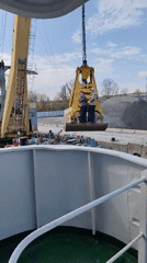 Crane loads gravel onto barge in Yakhroma, Russia