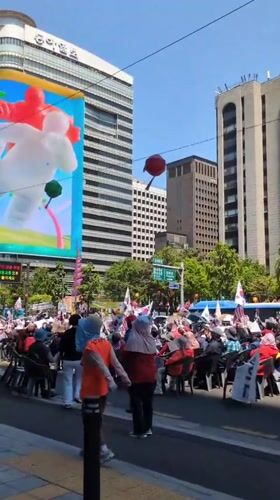 Seoul crowd gathers with flags, watches LED screen demonstration