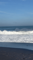 Early morning beach activity captured on Kediri's black sand shores