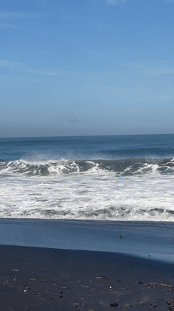 Early morning beach activity captured on Kediri's black sand shores