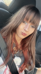 Passenger seat moment in Raanana, grey graphic tee and pink-tinted hair