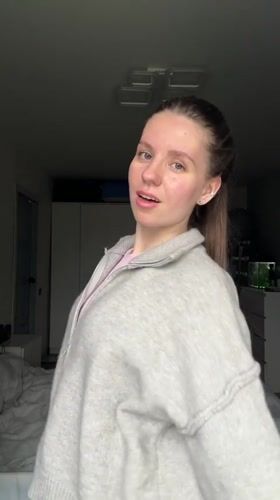 Young woman documents herself dancing, posing in Klin bedroom