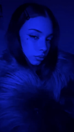 Woman with facial piercings photographed in blue light, Buenos Aires