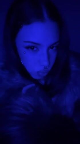 Woman with facial piercings photographed in blue light, Buenos Aires