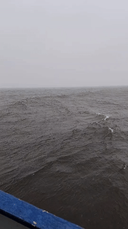 Cargo ship crew works through fog near Shcheleiki, Russia