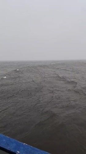 Cargo ship crew works through fog near Shcheleiki, Russia