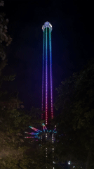 Illuminated drop tower ride observed at nighttime amusement park