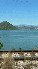 Train travels through Kruševica, Montenegro along white rock tracks