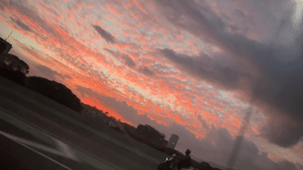 Motorcyclist silhouetted against dramatic sunset in Caracas