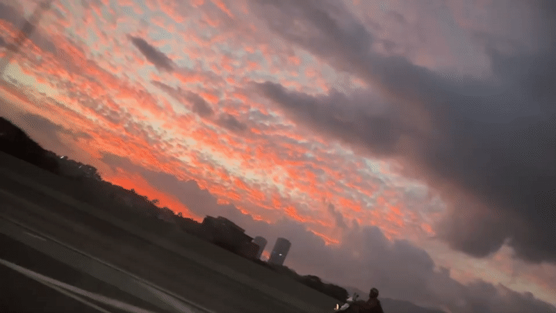 Motorcyclist silhouetted against dramatic sunset in Caracas