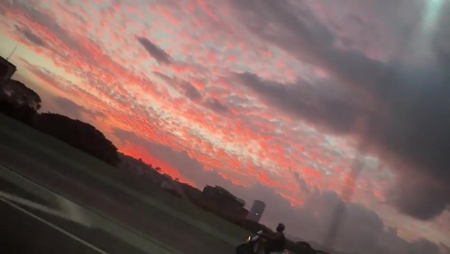 Motorcyclist silhouetted against dramatic sunset in Caracas