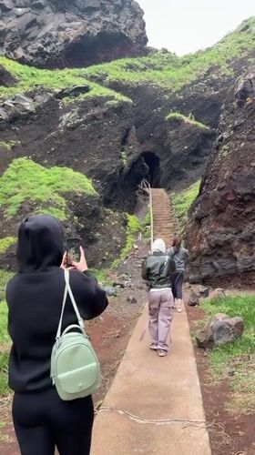 Tourists photograph coastal formations at Porto Moniz lava tubes