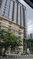 Street-level views of a cloudy Bangkok morning near residential towers