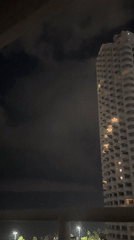 Nighttime balcony view captures illuminated high-rise in Pattaya