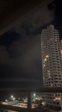 Nighttime balcony view captures illuminated high-rise in Pattaya