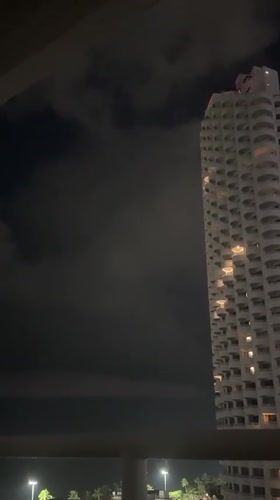 Nighttime balcony view captures illuminated high-rise in Pattaya