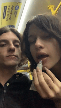 Two young people observed standing together on Buenos Aires bus