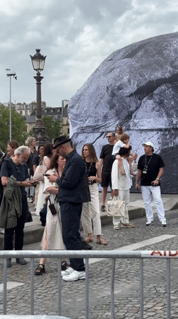 Crowds and river traffic along the Seine on a June afternoon