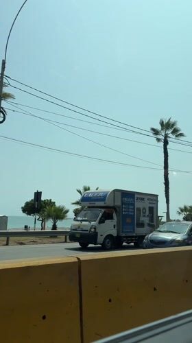 Traffic flows along palm-lined coastal road in Miraflores
