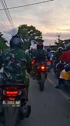 Military motorcyclists gather on road in Keudebayu, Indonesia