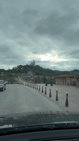 Vehicle approaches historic Tsarevets Fortress in Bulgaria under cloudy skies