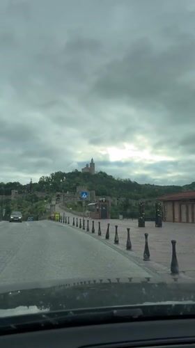 Vehicle approaches historic Tsarevets Fortress in Bulgaria under cloudy skies