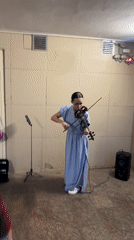 Musician performs violin as Kazan captures evening cityscape moments