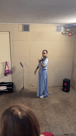 Musician performs violin as Kazan captures evening cityscape moments