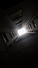 Upward view captured through narrow Buenos Aires courtyard passage