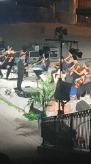 Outdoor orchestral concert under the night sky in Scordia