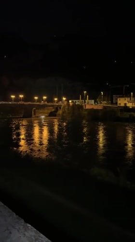 Night cycling along Trento's Adige River, Chiesa di San Vigilio glowing overhead
