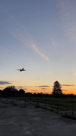 Aircraft lands at Otopeni airport during sunset twilight