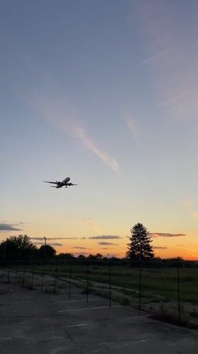 Aircraft lands at Otopeni airport during sunset twilight