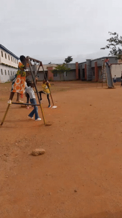 Playground swings and an indoor gathering, same moment
